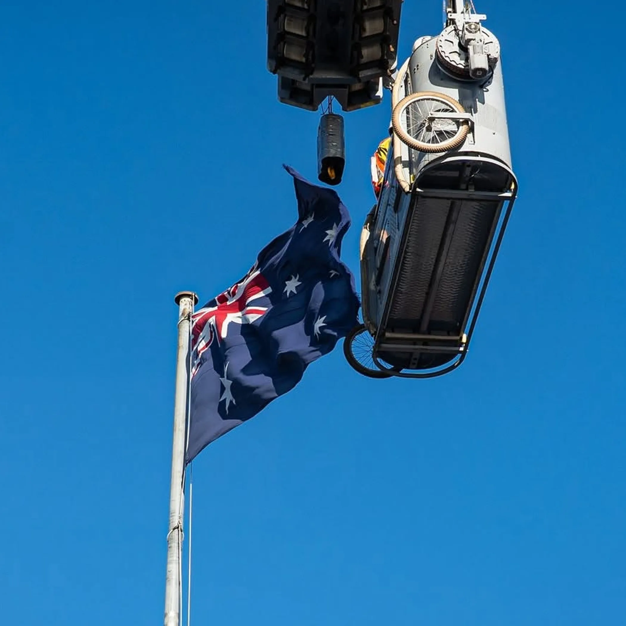 suspended access equipment beside australian flag
